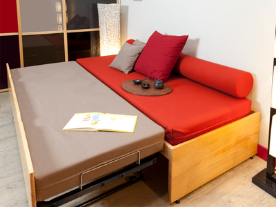 Lit gigogne MASSAKO 400 déplié en lit double : structure en pin clair, matelas rouge et gris, esprit moderne.