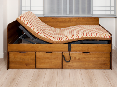 Lit tiroirs MASSAKO électrique en bois, mécanisme motorisé visible, matelas à motifs pois, commande filaire et tiroirs.